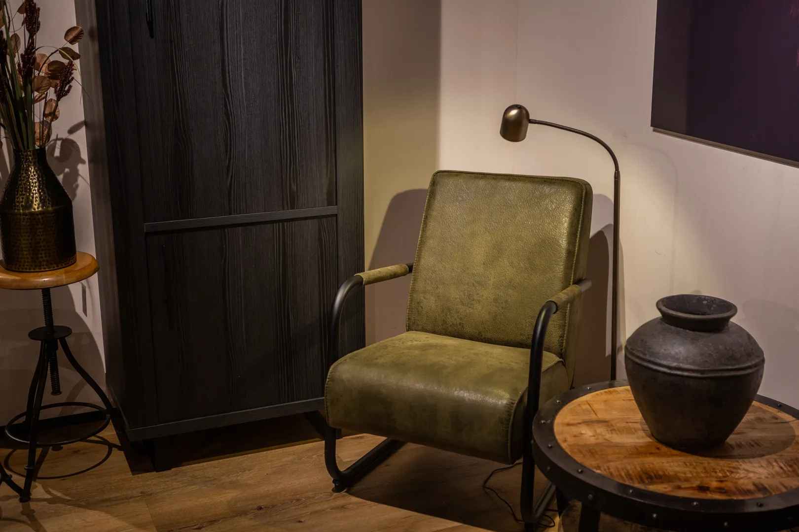 Klassieke woonstijl groene fauteuil en zwarte kast