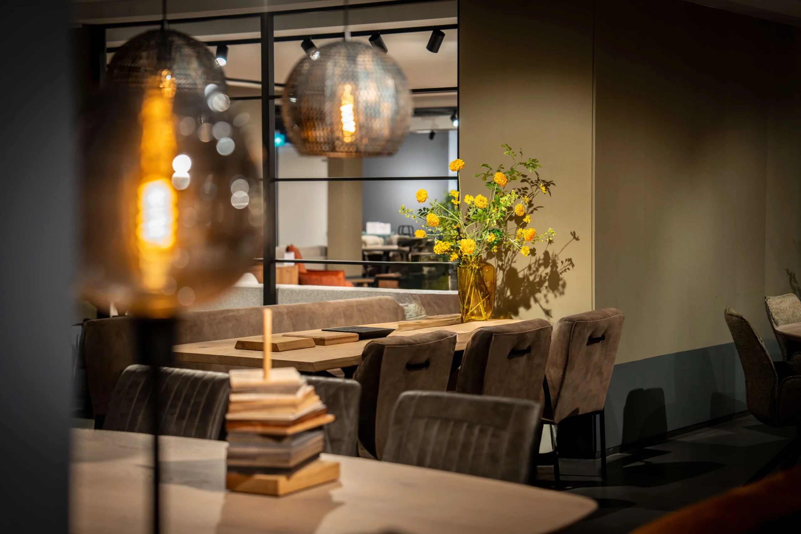 Eetkamerstoelen en een rechthoekige houten eettafel op de achtergrond van sfeerverlichting