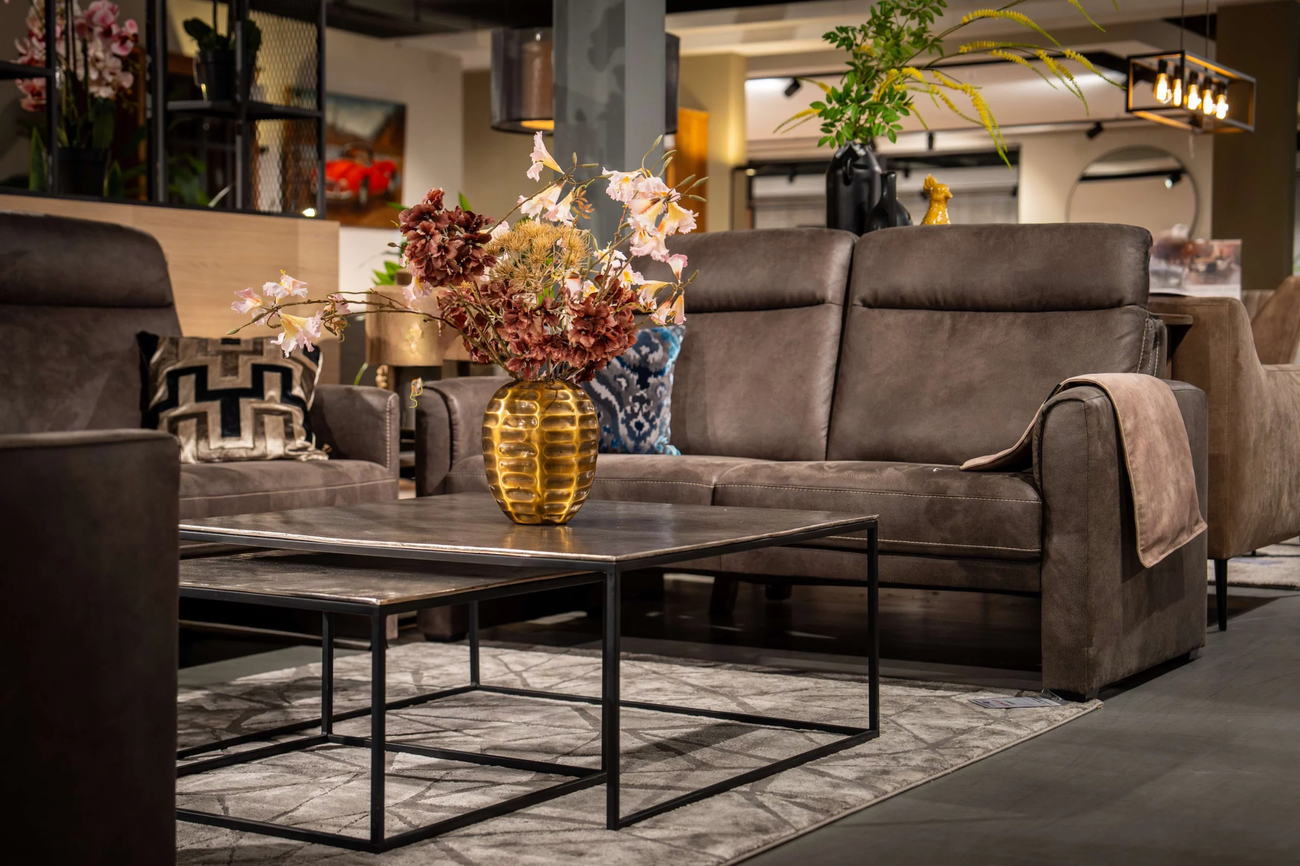 Antraciet zitbank met metalen salontafel en woonaccessoires