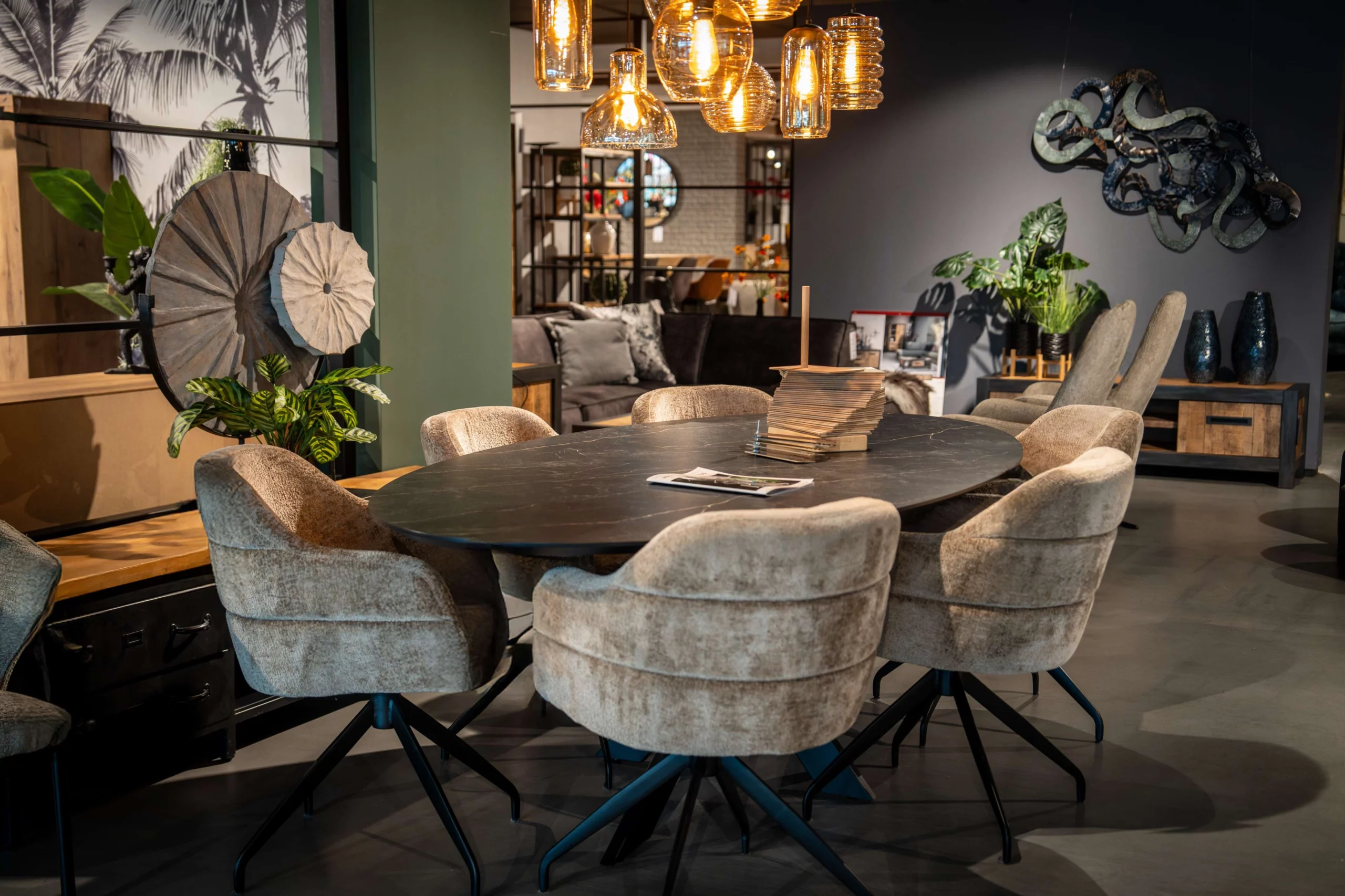 Zwarte ovalen eettafel met moderne lichte stoffen eetkamerstoelen