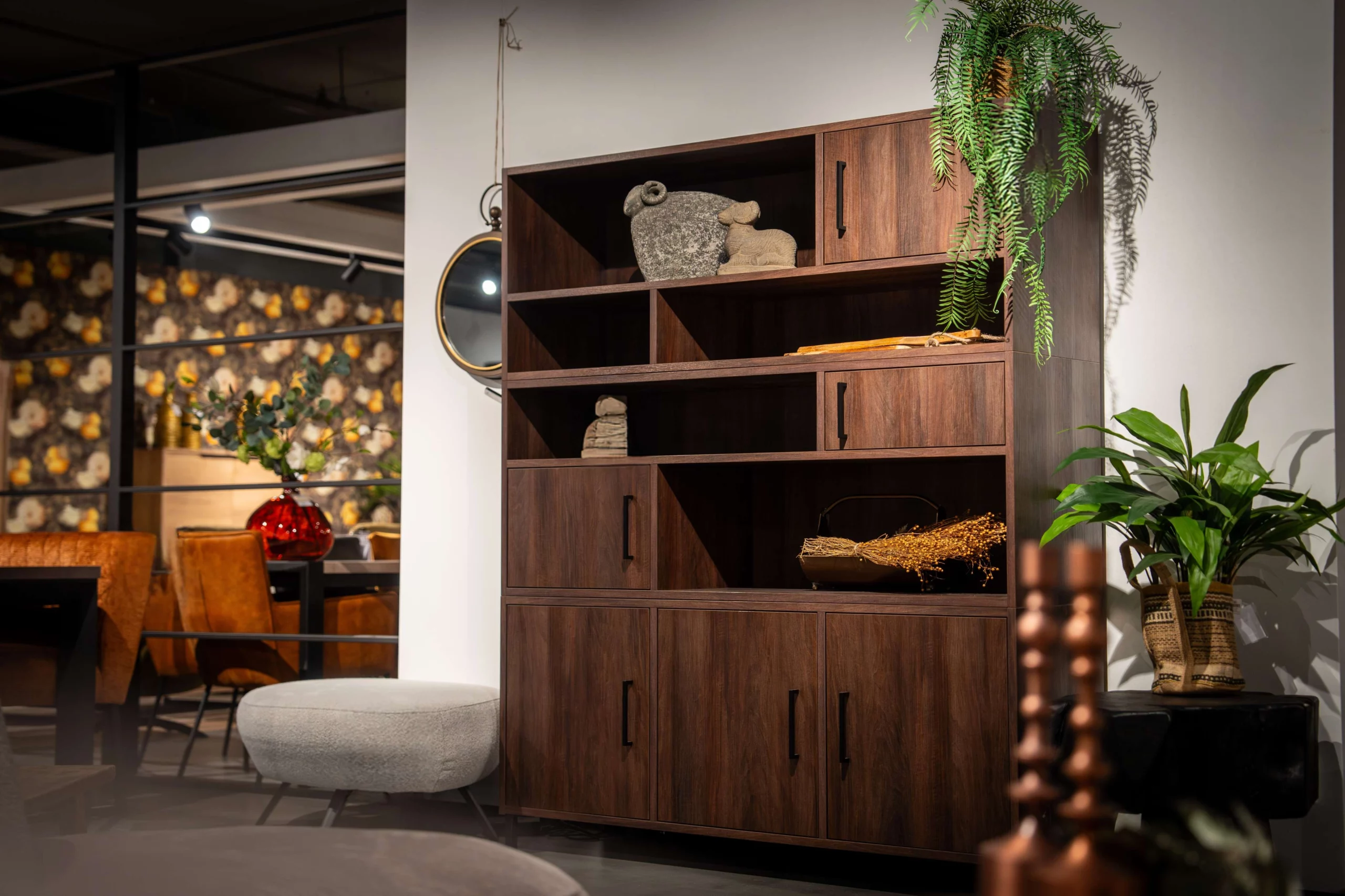Donkerbruine wandkast met open en dichte vakken en woonaccessoires erin
