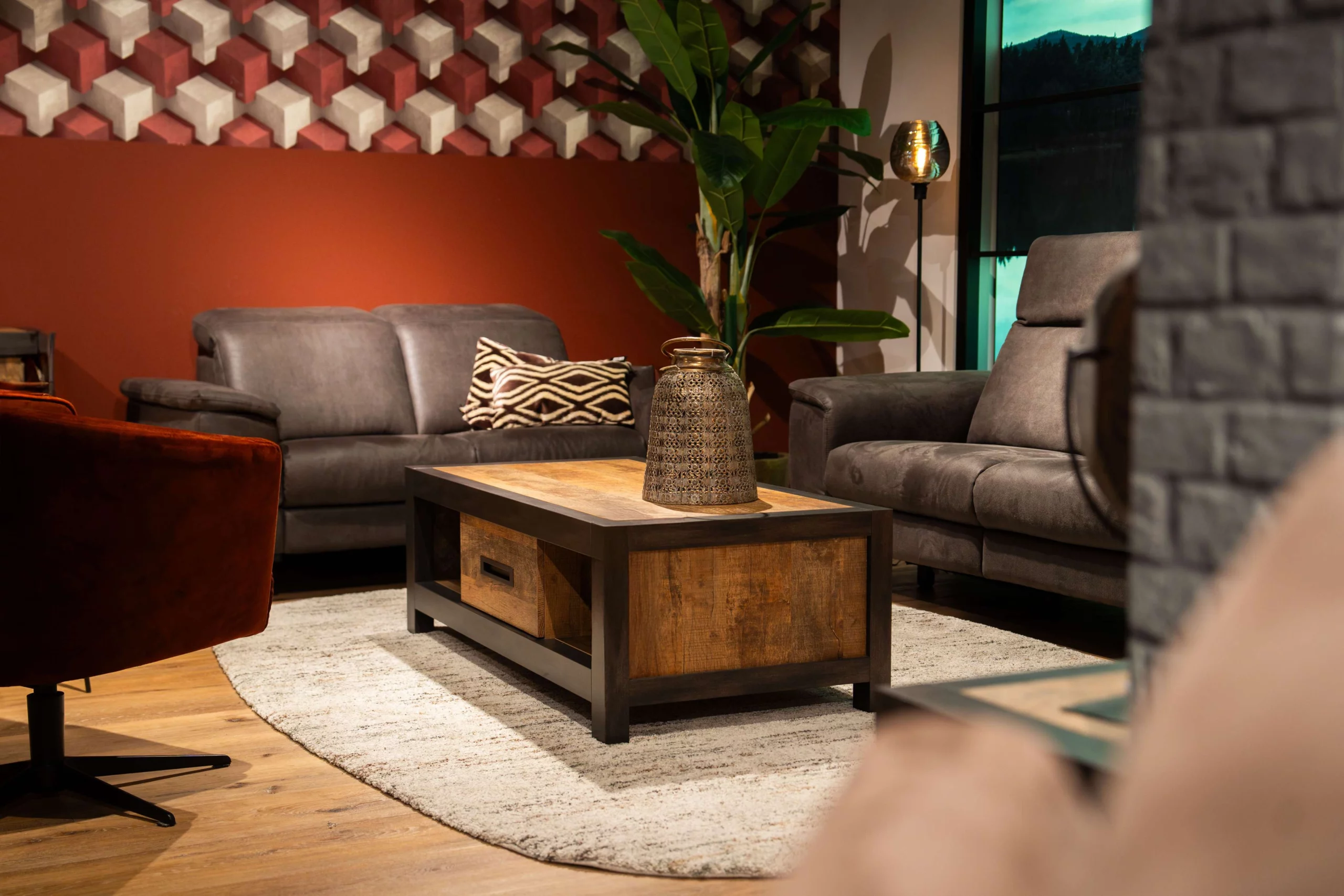 Industriële houten metaal salontafel voor een antraciet bank op een wit vloerkleed