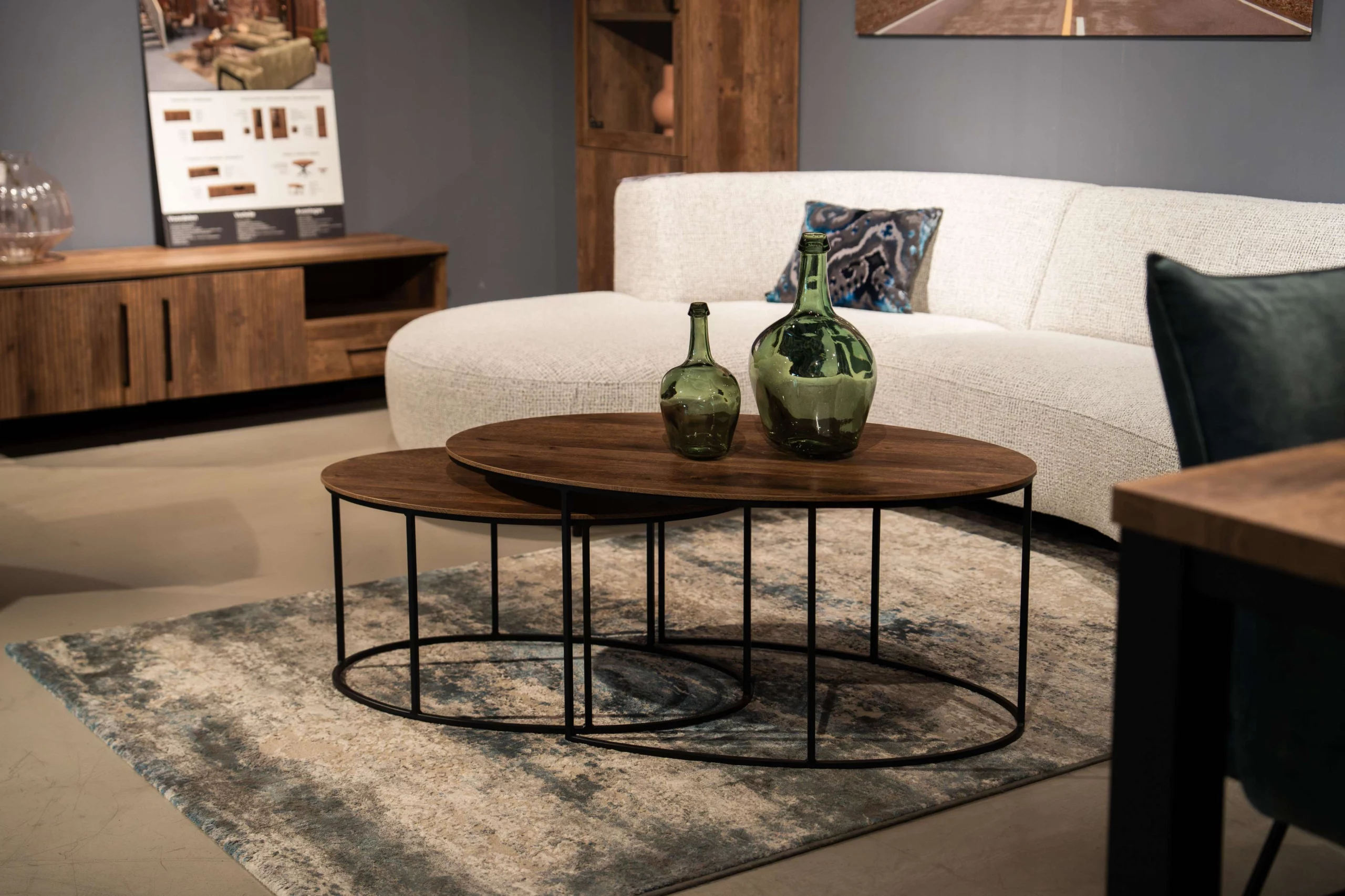 Moderne donkere houten salontafel met een witte stoffen hoekbank met ronde vormen