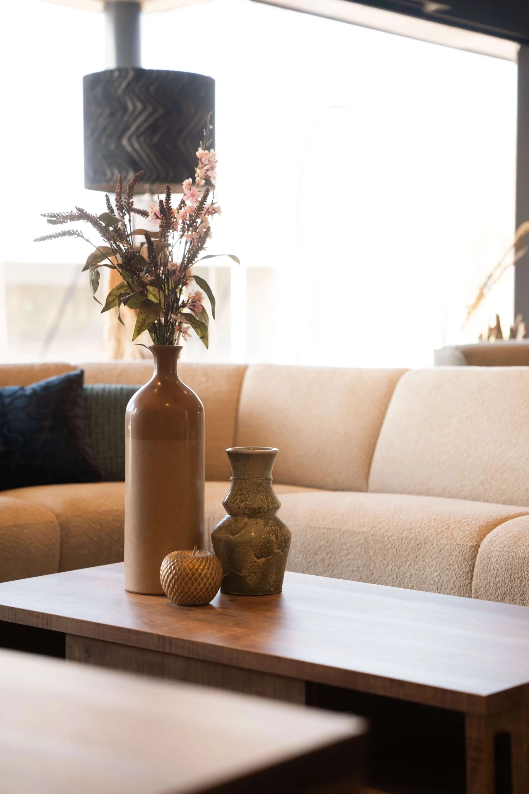 Moderne woonstijl accessoires op een moderne salontafel met een witte stoffen bank op de achtergrond