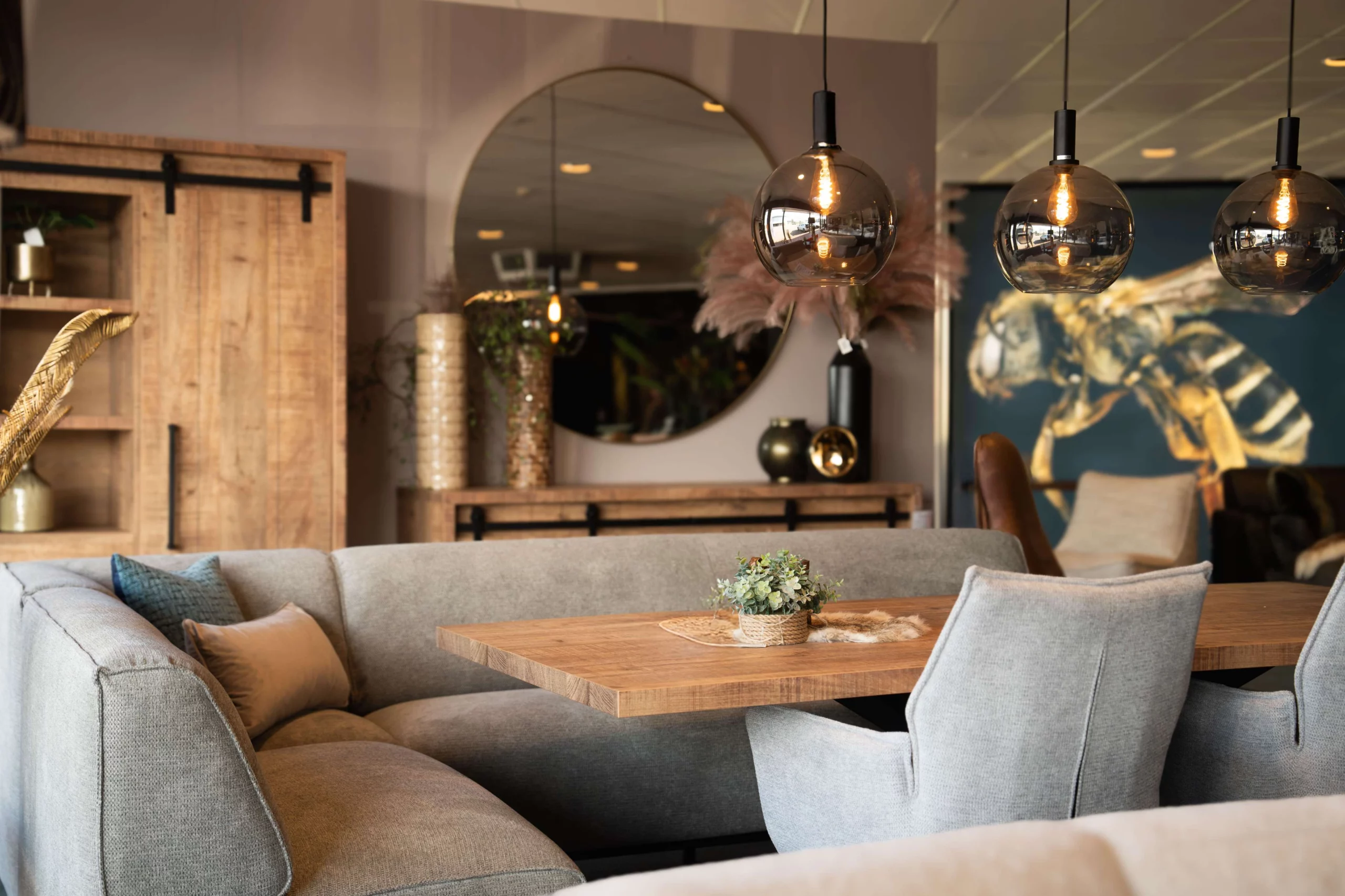 Eetkamer hoekbank grijs rondom een kleine eettafel en lichte eetkamerstoelen