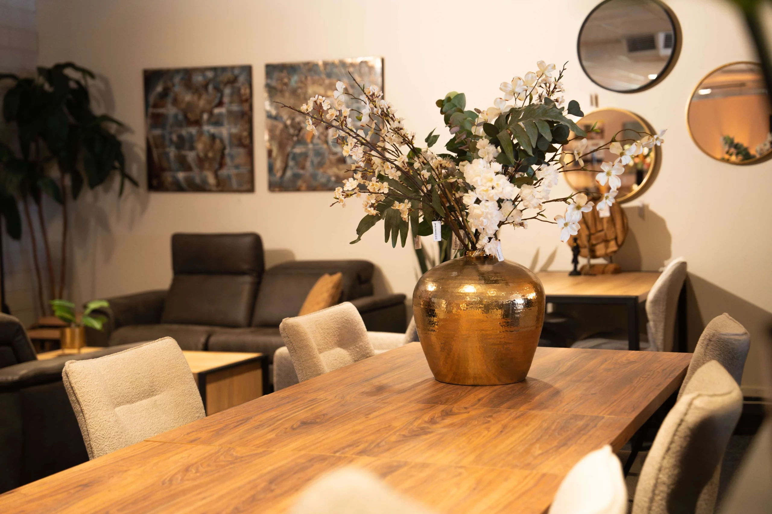 Gouden vaas op klassieke houten eettafel met witte eetkamerstoelen