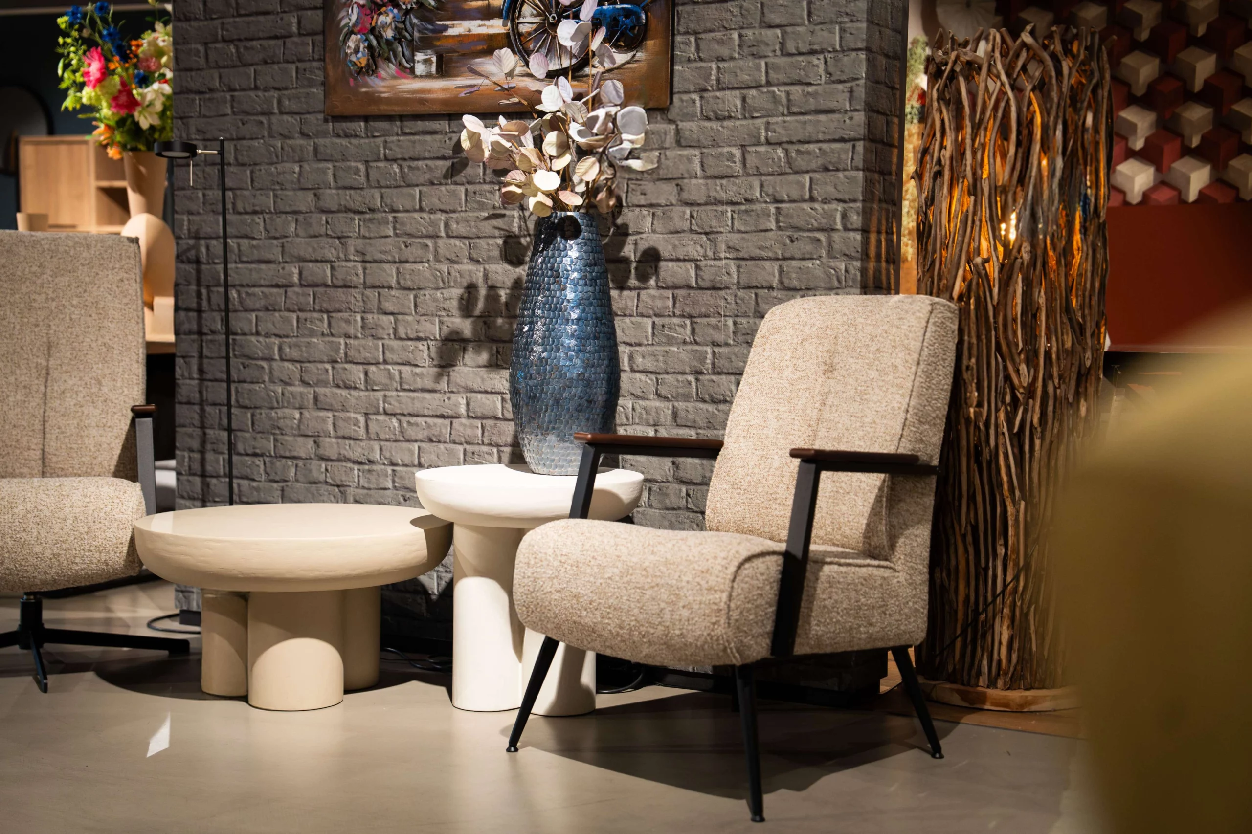 Stoffen fauteuil naast een vaas decoratie op een tafeltje